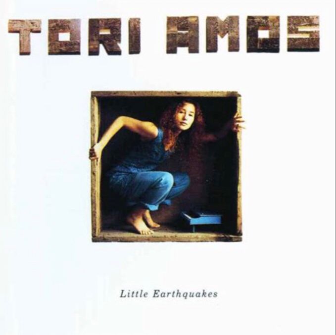 tori amos: little earthquakes
coverillustration zeigt die sängerin tori amos in einem blauen jeansoverall, sie hockt in einer holzbox, die sie fast ganz ausfüllt, neben ihr in derselben box steht ein miniaturklavier