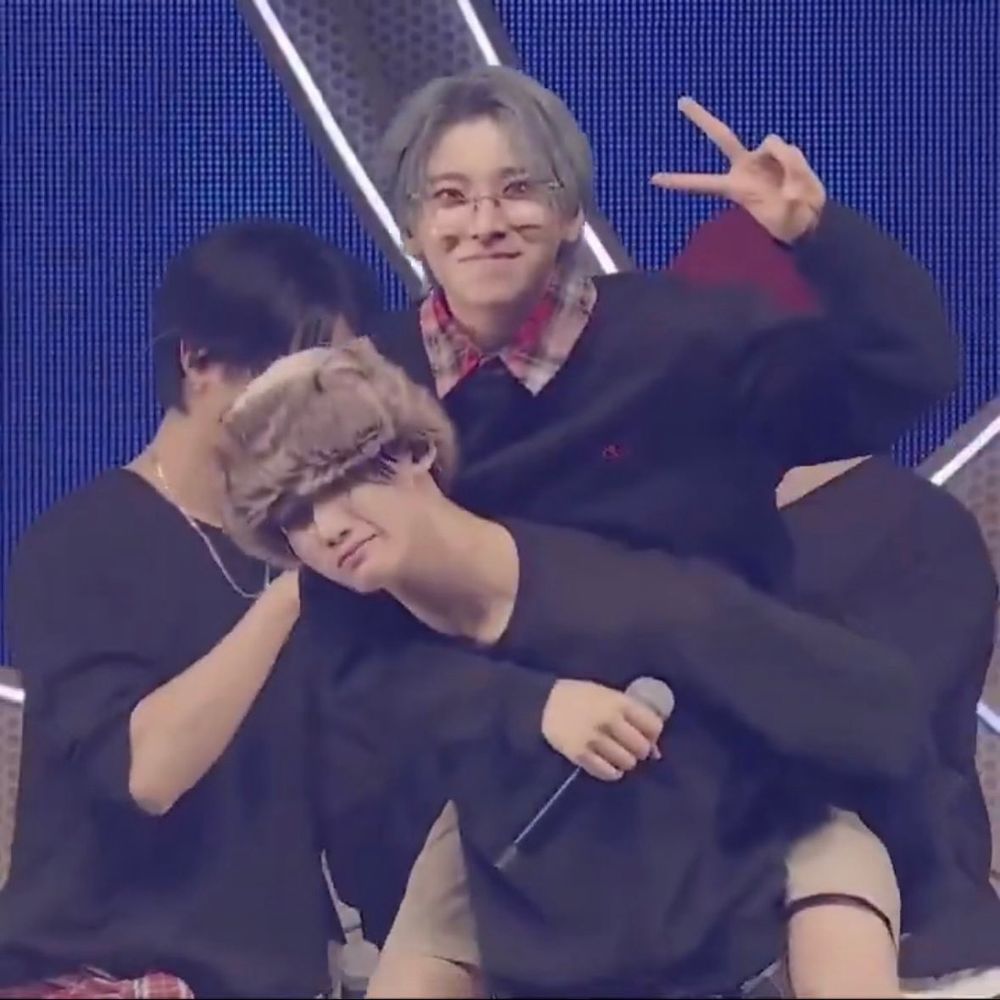 joyuma doing a new pose for their bit in illumination: jo carrying yuma piggyback style while yuma does a peace sign with his left hand