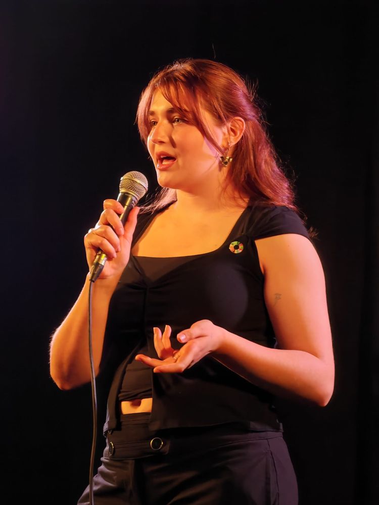 A UCL student climate comedian on stage.