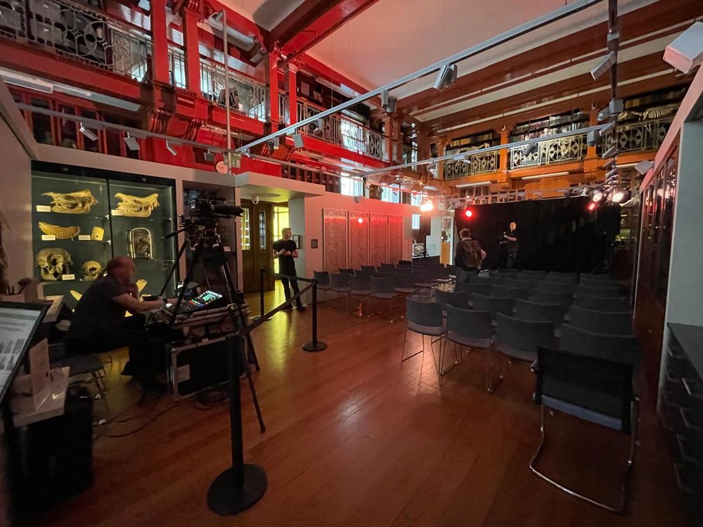 A photograph of the Grant Museum with a stage, lighting and audience seats.