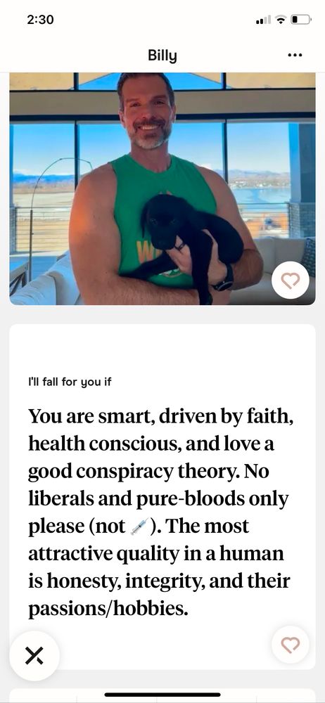 A screenshot of a dating profile with a picture where a man named Billy is holding a puppy. In his profile prompt below it says: “I’ll fall for you if you are smart, driven by faith, Health, conscious, and love a good conspiracy theory. No liberals and pure bloods only please (not ‘needle emoji’). The most attractive quality in a human is honesty, integrity, and their passions/hobbies.”