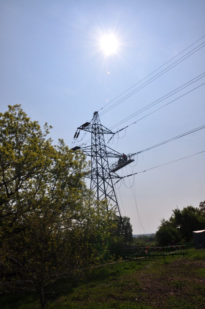 A transmission tower (“pylon”) with a temporary gondola where workers are doing maintenance.