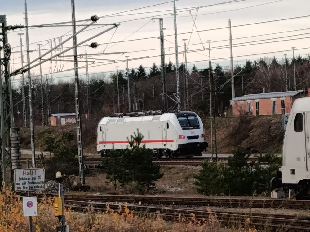 Eine weiße Lok der Baureihe 105 steht in der Abstellung.
