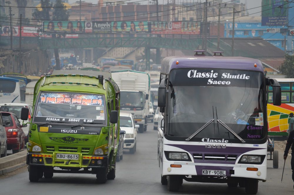 Motorway in Nairobi with a bus on the right hand side and a lorry on the left hand side facing the camera