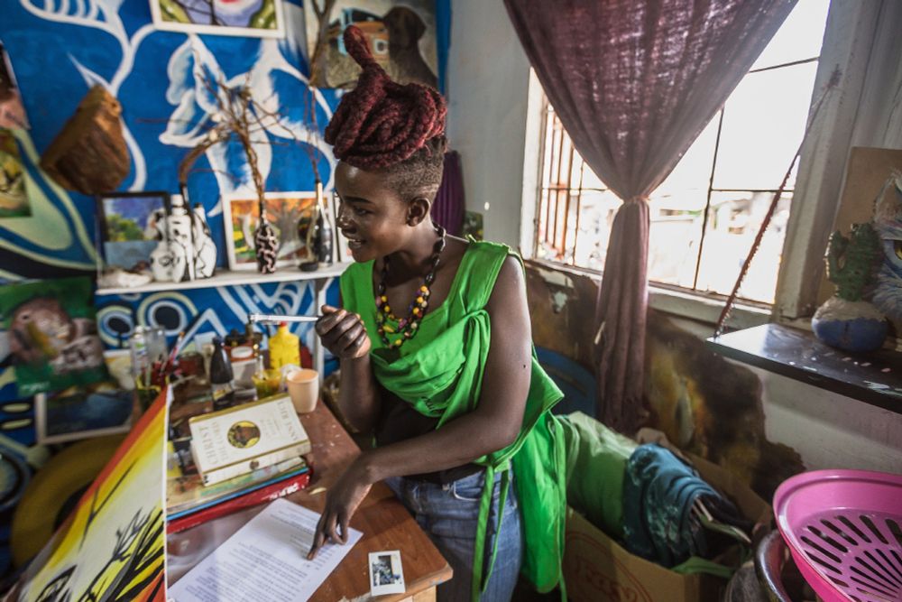 Female artist is signing a paper in her studio