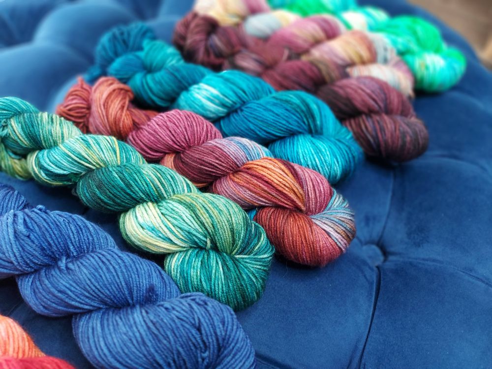 A line up of various variegated skeins of yarn 