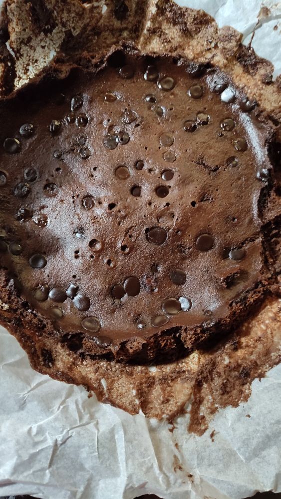 Fotografía de un brownie, bizcocho de chocolate redondo hecho con plátano y pepitas de chocolate por encima