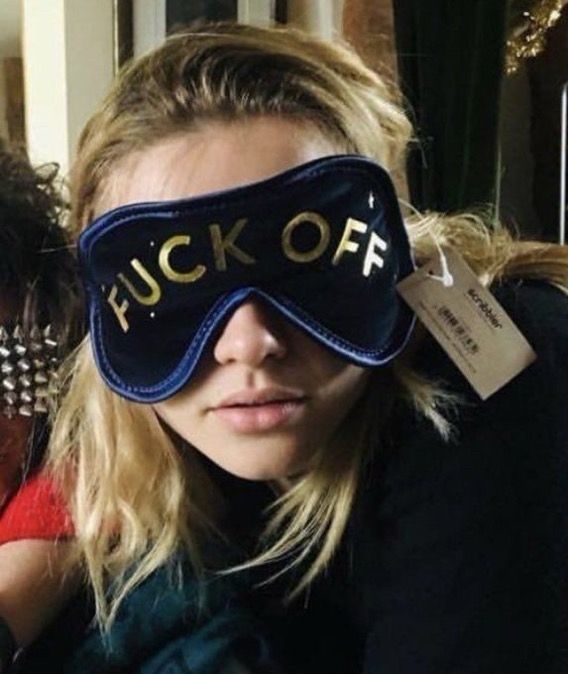 Florence Pugh wearing an eye mask that says “fuck off”.