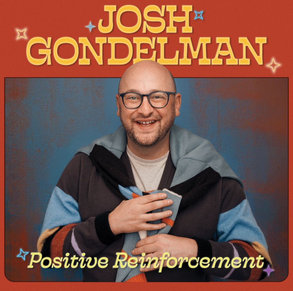 Positive Reinforcement cover art!!! I’m wearing a cardigan with another cardigan draped over my shoulders. My name and the title are kind of styled like the Big Lebowski opening titles!