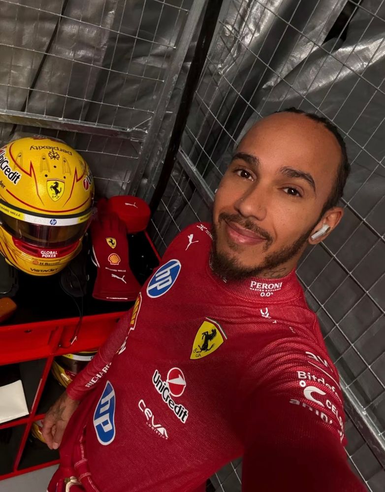 Lewis posing in his race suit 