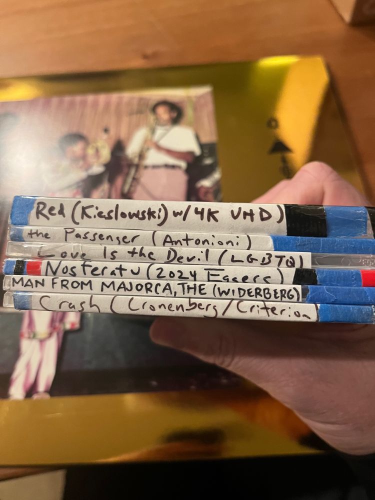 photo of a hand holding six blu rays:

-Red (Kieslowski)
-The Passenger
-Love Is The Devil
-Nosferatu
-Man From Majorca
-Crash