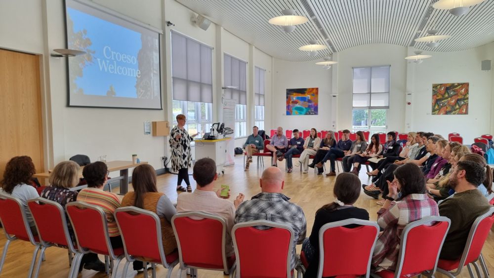 A group of future research leaders sitting in a semi circle while Dani speaks from the middle