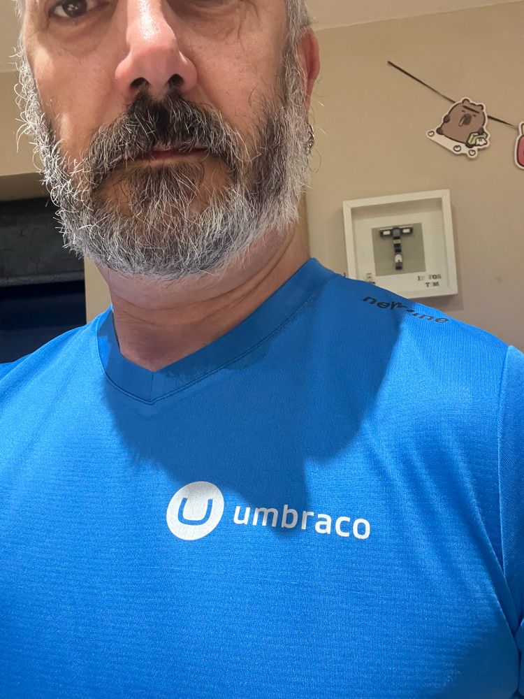 Picture shows an older chap with a beard wearing a promotional Umbraco running top