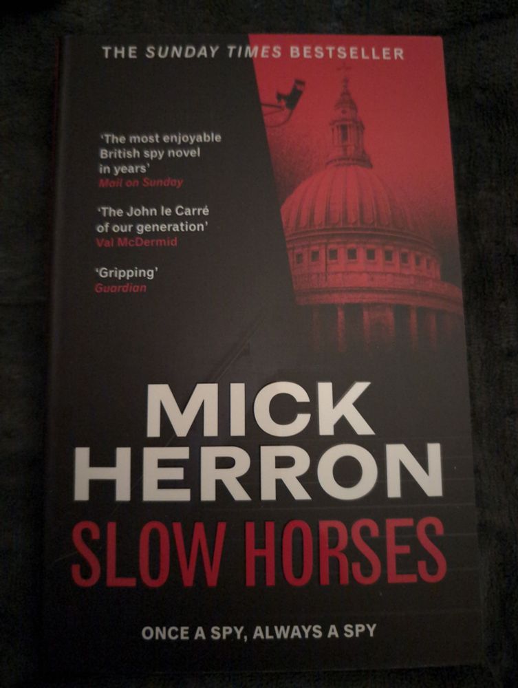 The front cover of the spy thriller Slow Horses by Mick Herron.
"The most enjoyable British spy novel in years" - Mail on Sunday
"The John le Carré of our generation". - Val McDermid
"Gripping" - Guardian
Once a Spy, Always a Spy