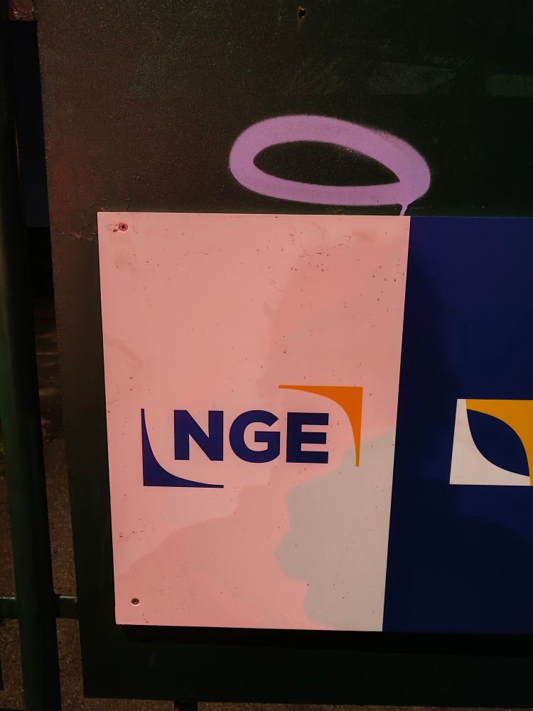 un panneau publicitaire pour l'entreprise NGE, il y a marqué NGE dessus, une auréole est taguée au dessus