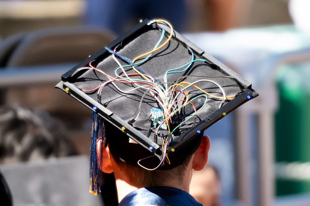 Graduate wearing a decorated cap with electronic components and wires. (Photo by Adam Lau / Berkeley Engineering)