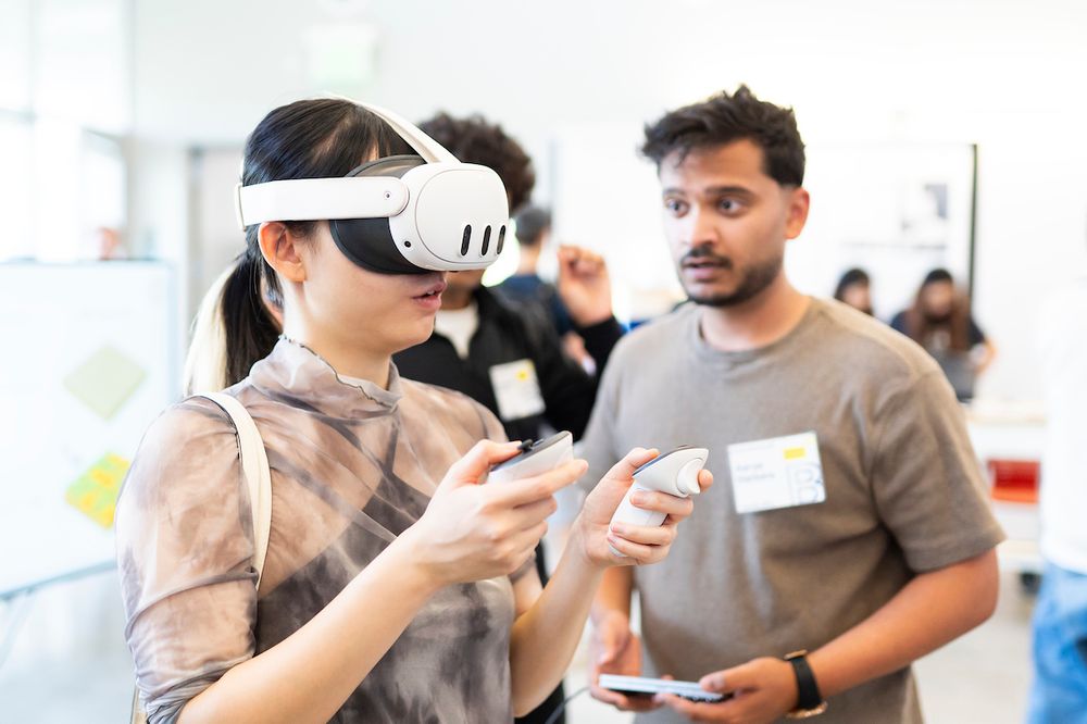 An attendee wears a headset and holds two remotes. (Photo by Adam Lau / Berkeley Engineering)
