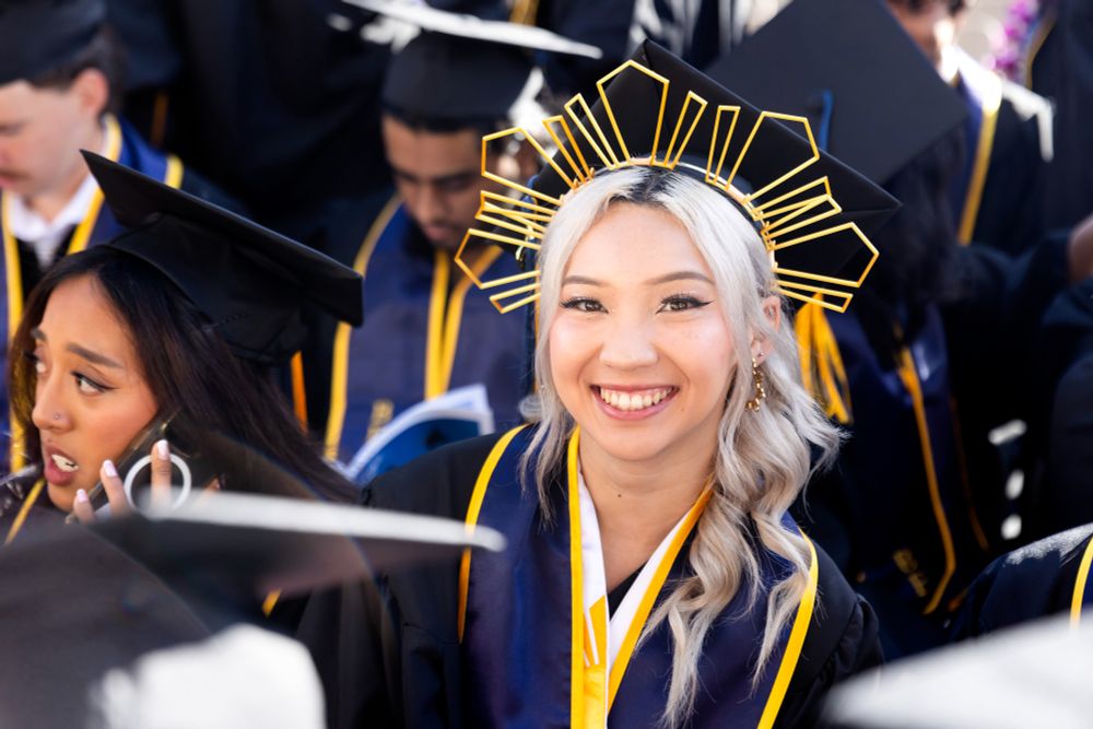 A graduate smiles while wearing a golden crown above a graduation cap. (Photo by Brittany Hosea-Small)