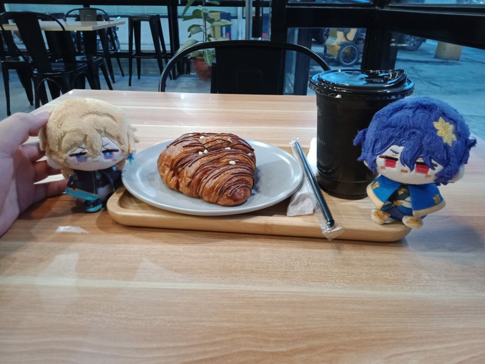 a tray with nutella croissant and an auro choco strawberry drink with ratio and aventurine doll on both sides