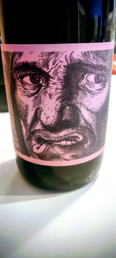 A wine label. A man biting his lower lip.