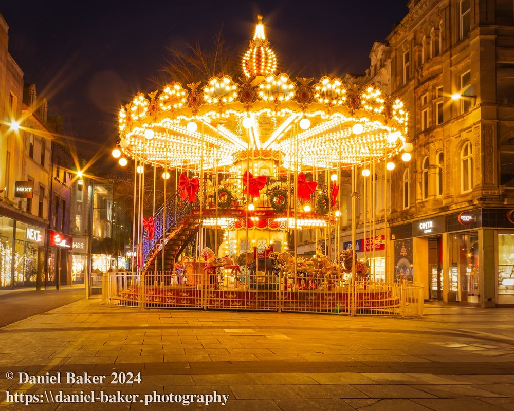 A Christmas carousel in a street at night