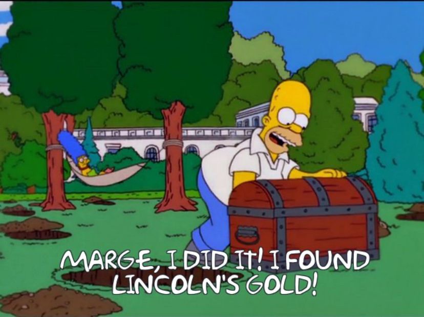 A screenshot from an episode of the Simpsons in which Homer has unearthed a wooden chest, from a lawn pockmarked with holes, while Marge watches from a hammock. The White House can be seen in the background. The written-out dialogue reads “Marge, I did it! I found Lincoln’s Gold!”
