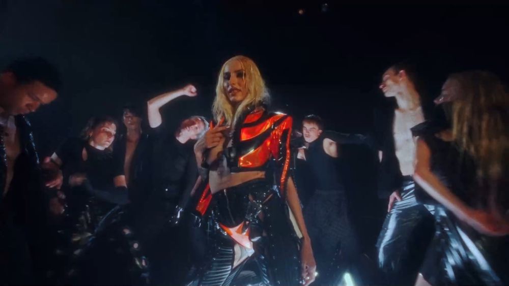 Raiven surounded by dancers, in music video for her song Mama