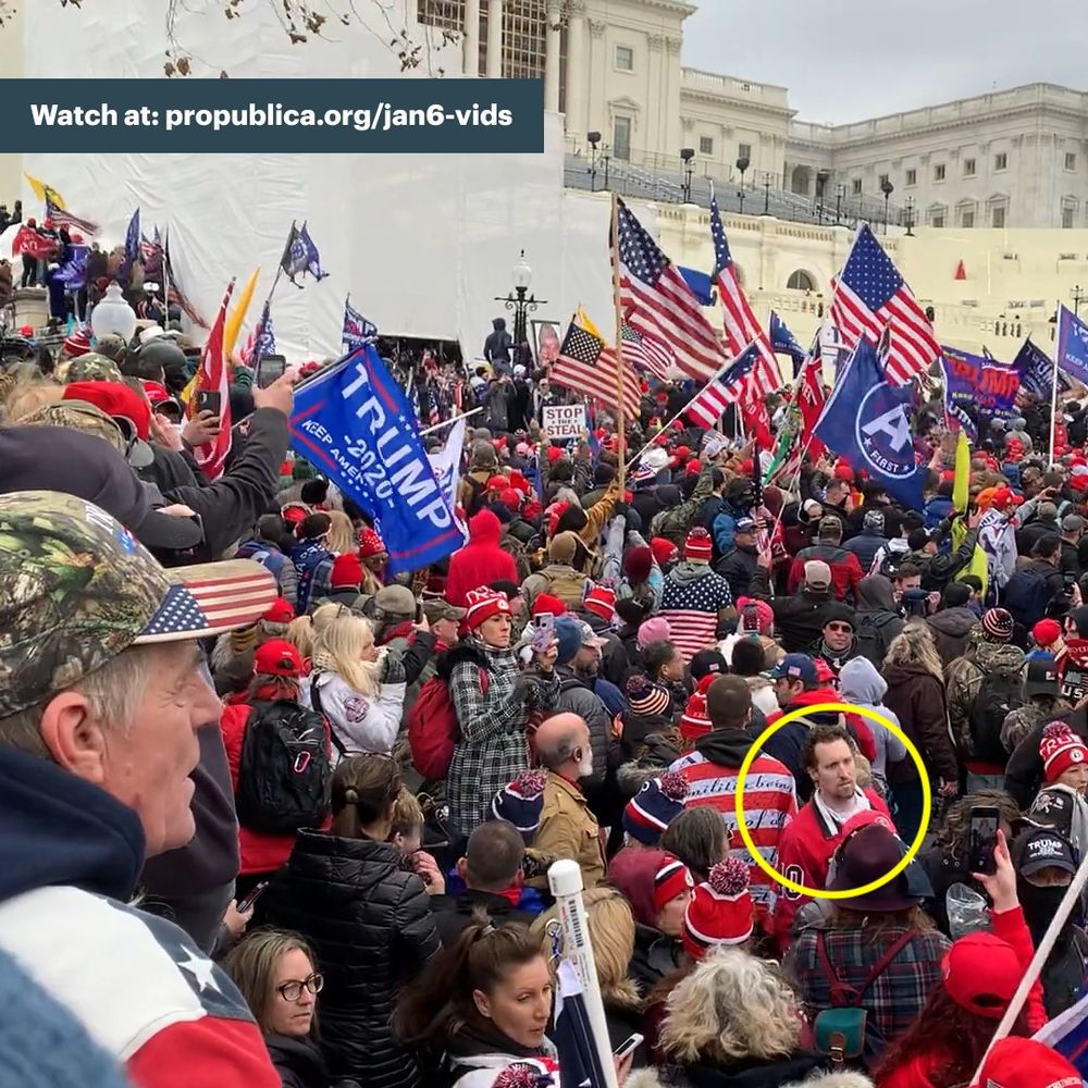 Screenshot of E.J. Antoni, a man with short brown hair and wearing a red shirt, moving in the bottom right corner through a crowd of Jan. 6 rioters on Capitol grounds.