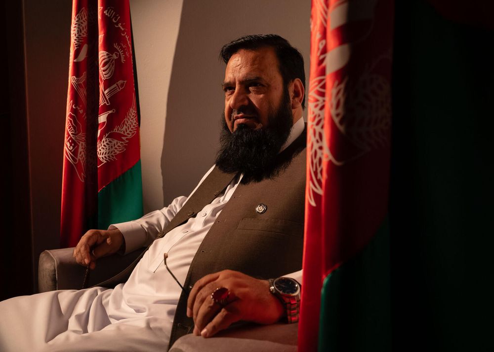 Photo of 53-year-old Afghan scholar Mohammad Halimi. He is sitting, wearing white pants and shirt with a brown vest.