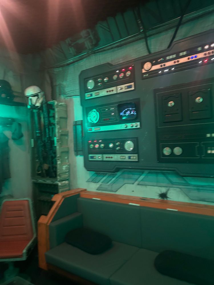 Control panel with lots of knobs, buttons and lights. A Storm Trooper helmet hangs to the side.