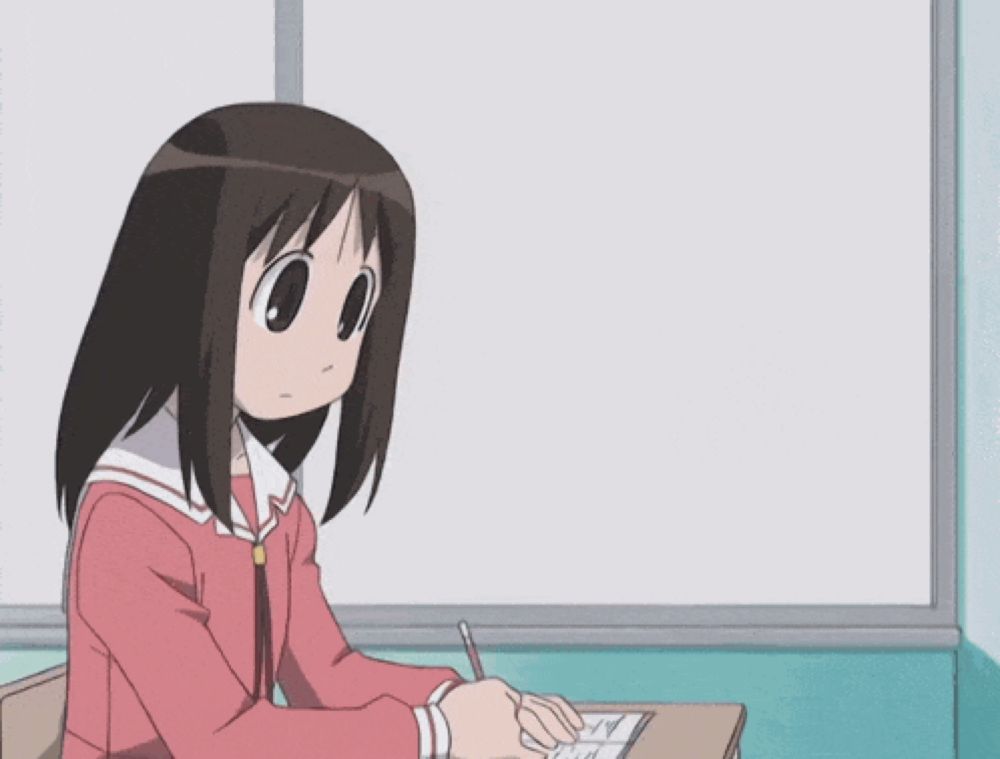 a girl in a pink jacket sits at a desk in front of a white board with a yellow cat on it