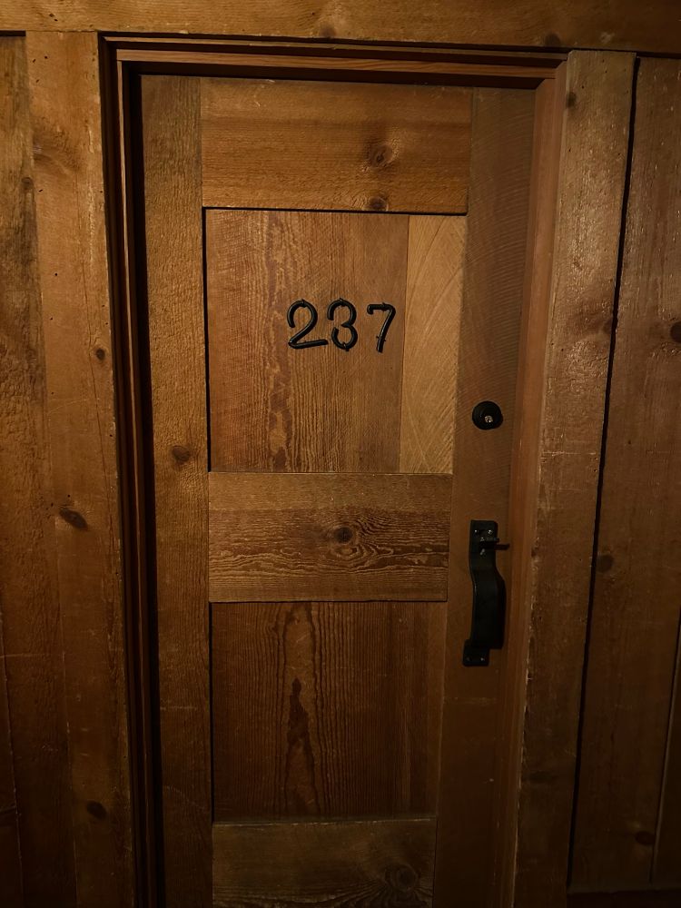 The wood paneled hallway and door to Room 237 of the Old Faithful Inn