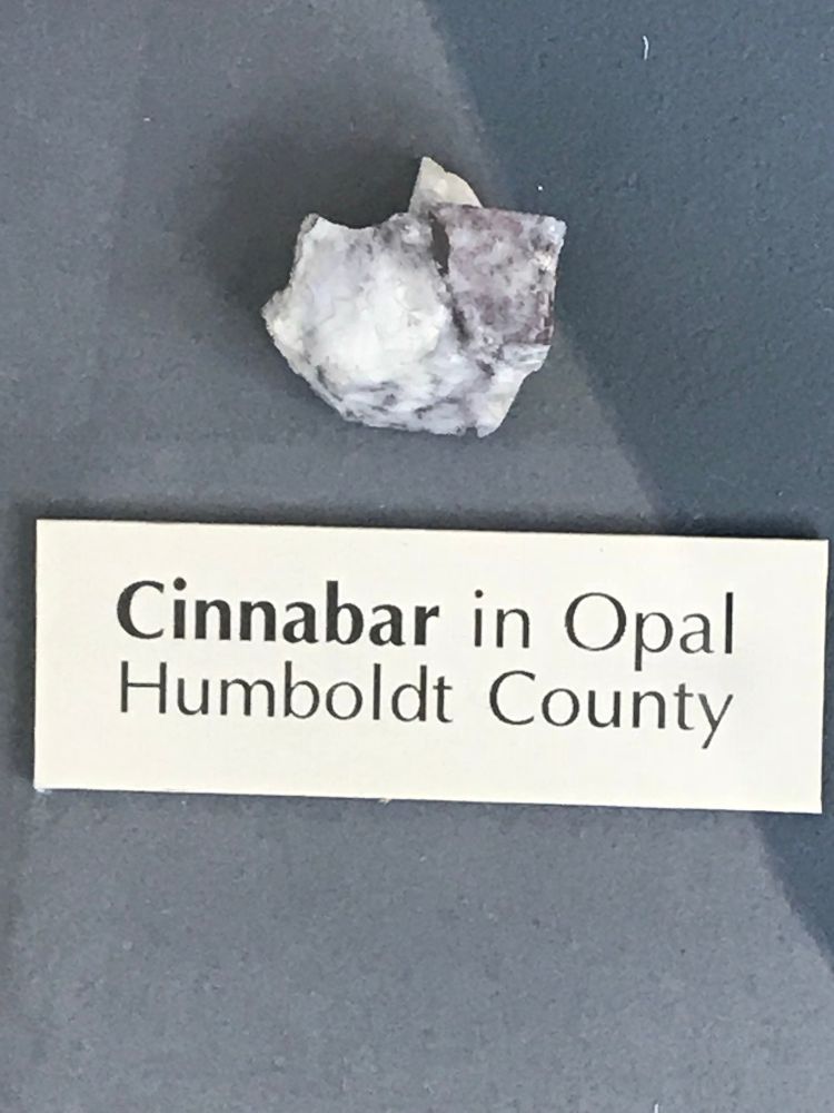 Mineral sample with museum plaque that reads:

“Cinnabar in Opal
Humboldt County”