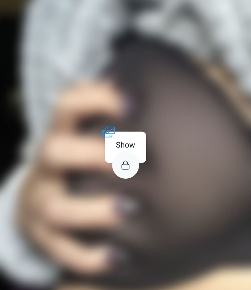 Blurred image of Raven gripping their boob with their nails
