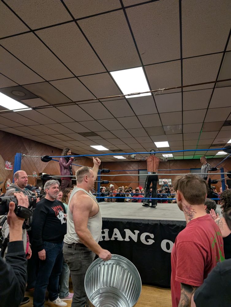 Dan champion entering with a metal trash can.