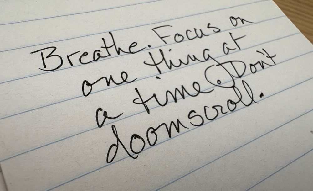 Handwritten reminder that says, “Breathe. Focus on one thing at a time. Don’t doomscroll.”