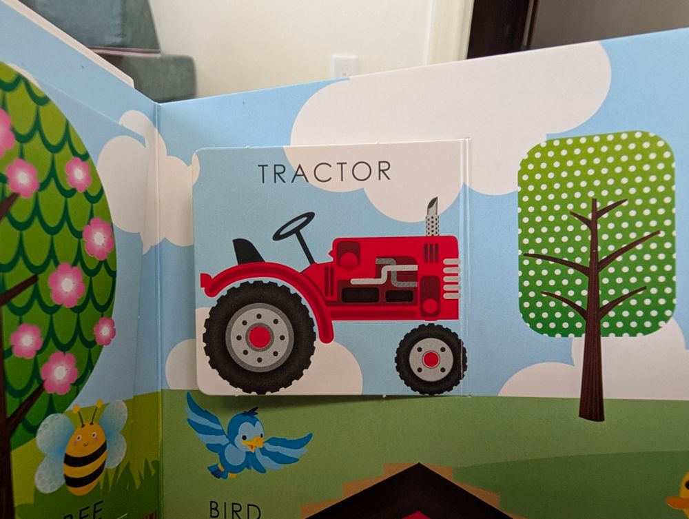 a lift-the-flap book with a picture of a tractor labeled 