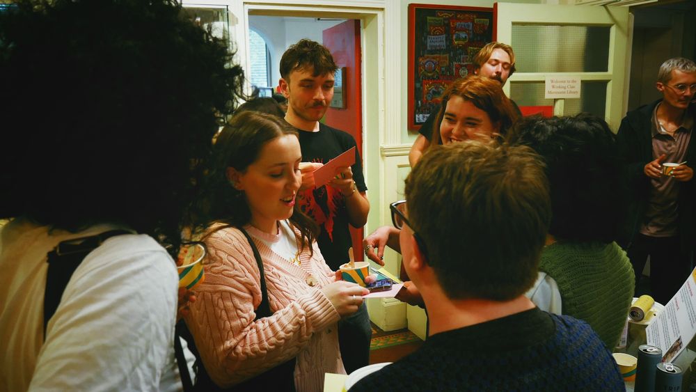 Some of the Little Flames group smile and talk by the entrance to the exhibition.