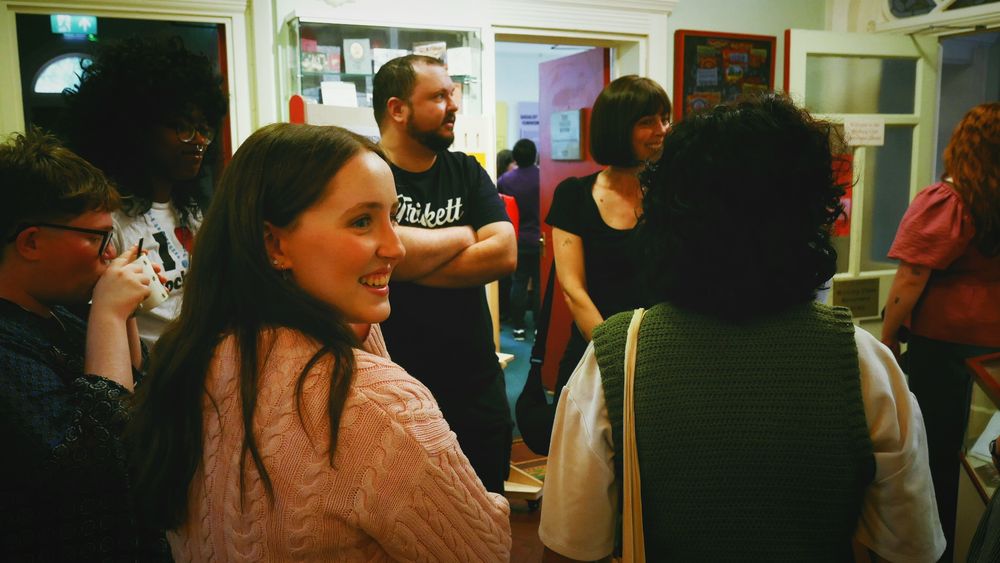 A group of young people and audience members talk in lively conversation.