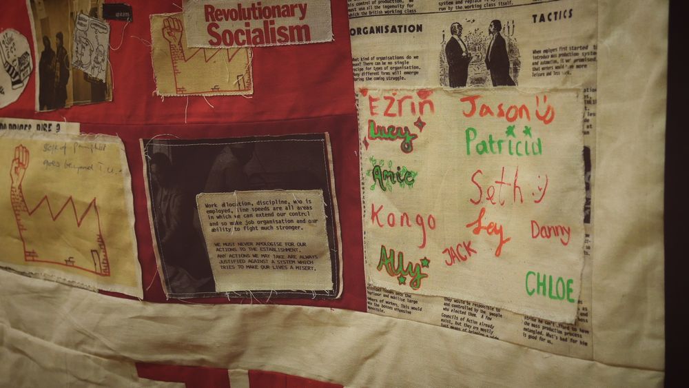 A close-up of the Little Flames banner, with a panel showcasing the names of everyone that worked on the project.