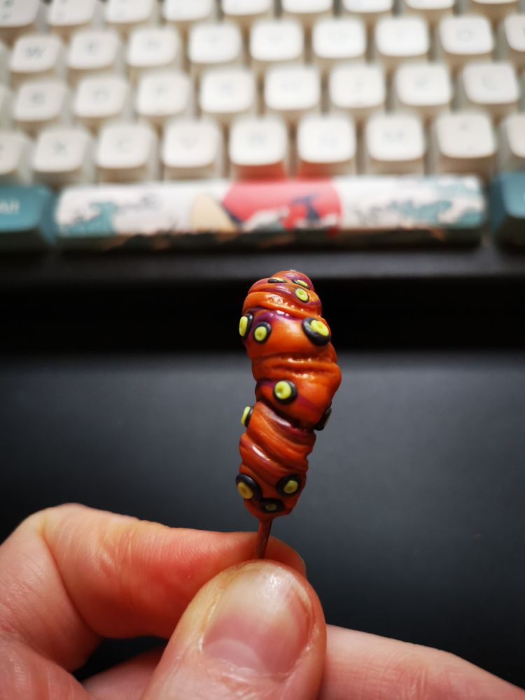 Orange brown twisted Chrysalis with black & yellow spots