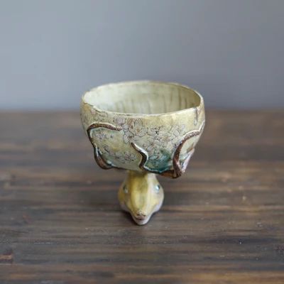 a deer head tea cup. the head is the base and the antlers re like vines crawling up the side of the cup
