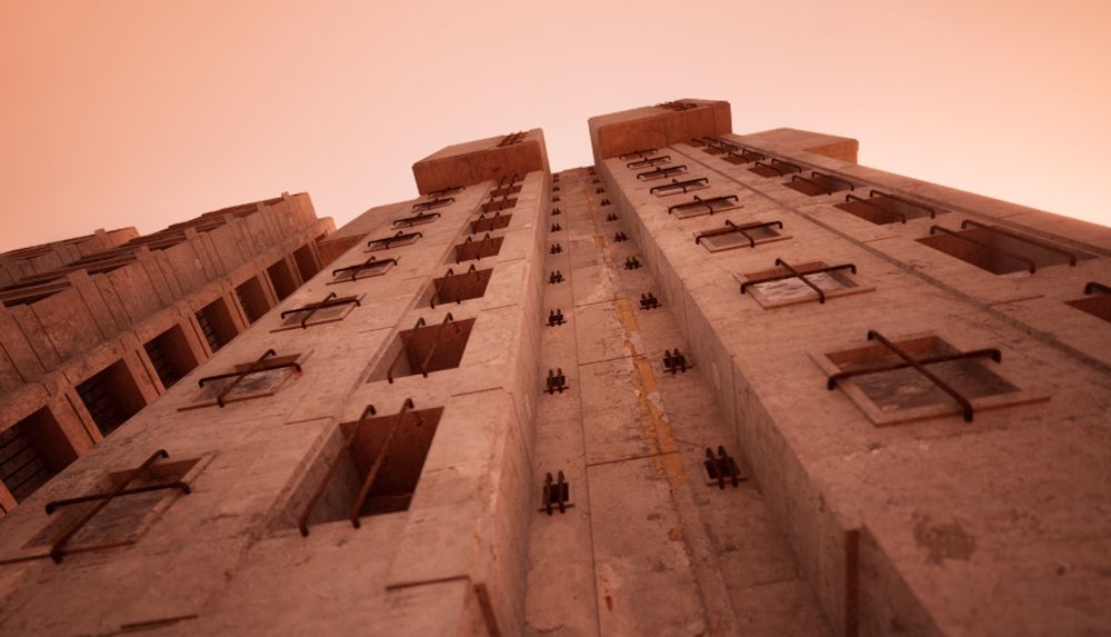 looking up at a brutalist concrete building, the varying windows each have bars on them