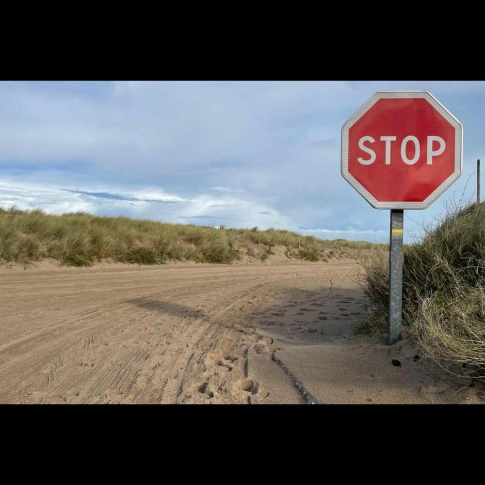 Vents violents. Une route complètement recouverte par du sable, en cours de déblaiement