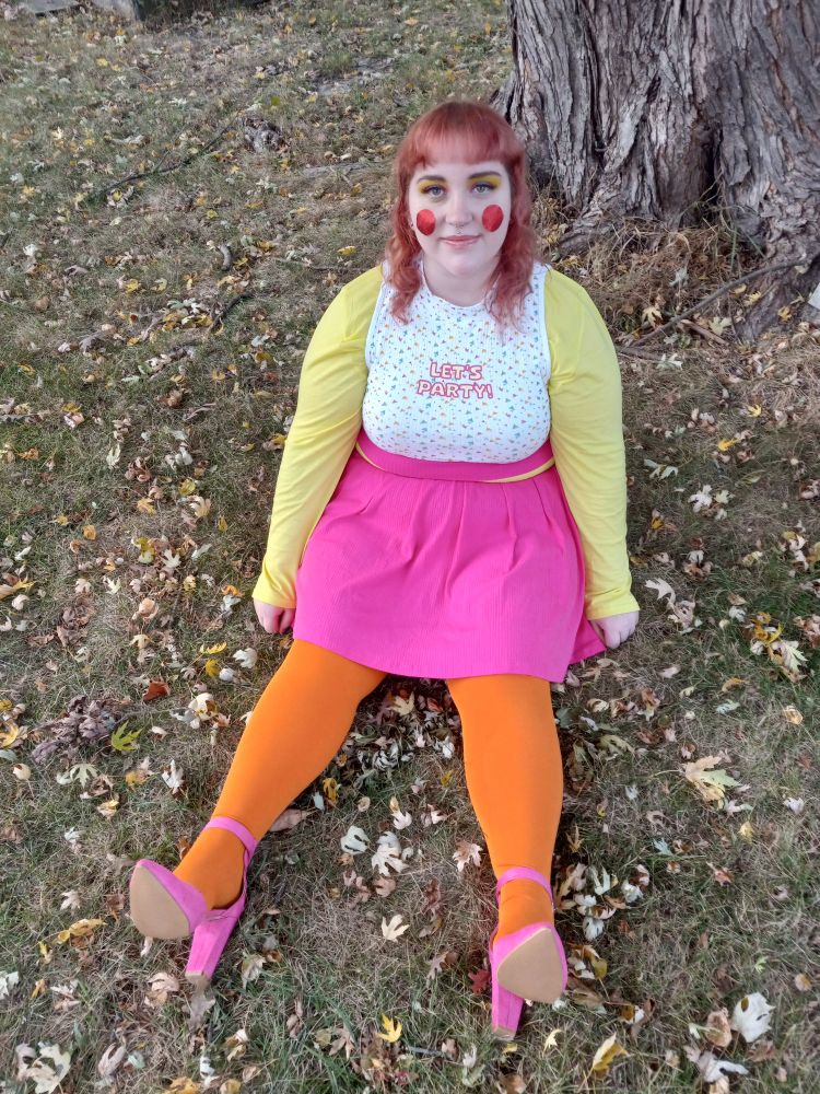 Photo of me sitting on the ground outside in my full Toy Chica costume 