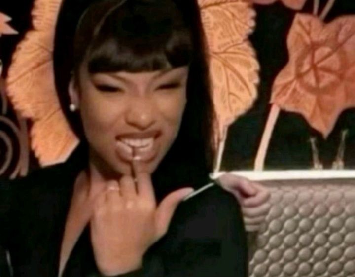 Megan the Stallion biting on her nail in a flirty way