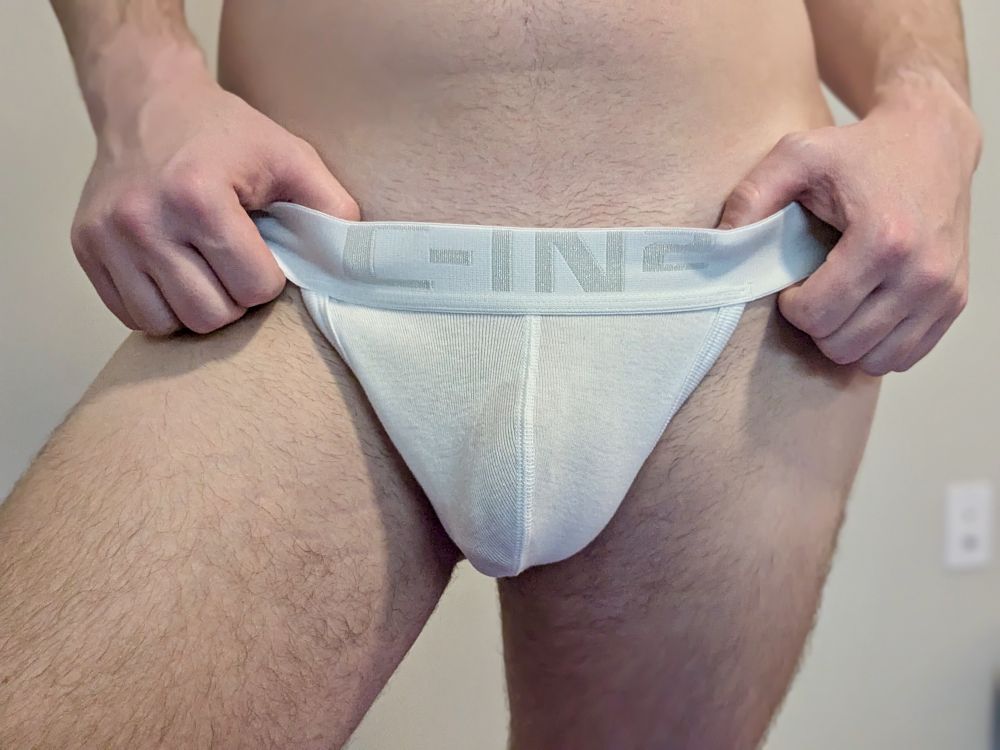 Photo of me in a white jock with my thumbs in the waist band on each side. My VPL is showing off.