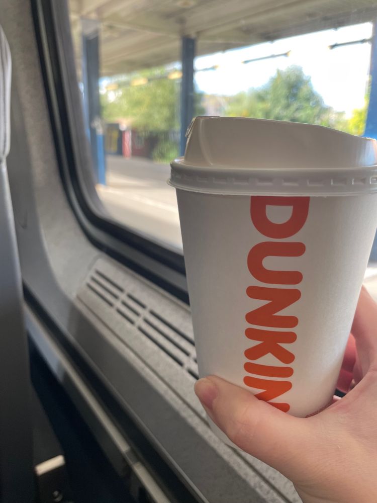 Holding a (disgusting, perfect) Dunkin’ cappuccino on the inside of an Amtrak, looking out at a Massachusetts train station