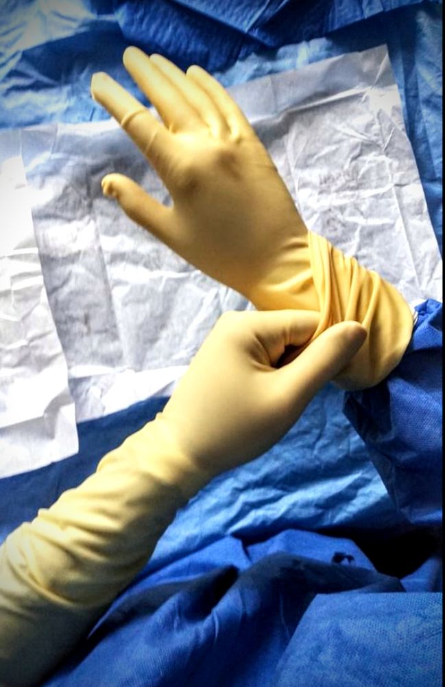 Surgeon correcting second glove