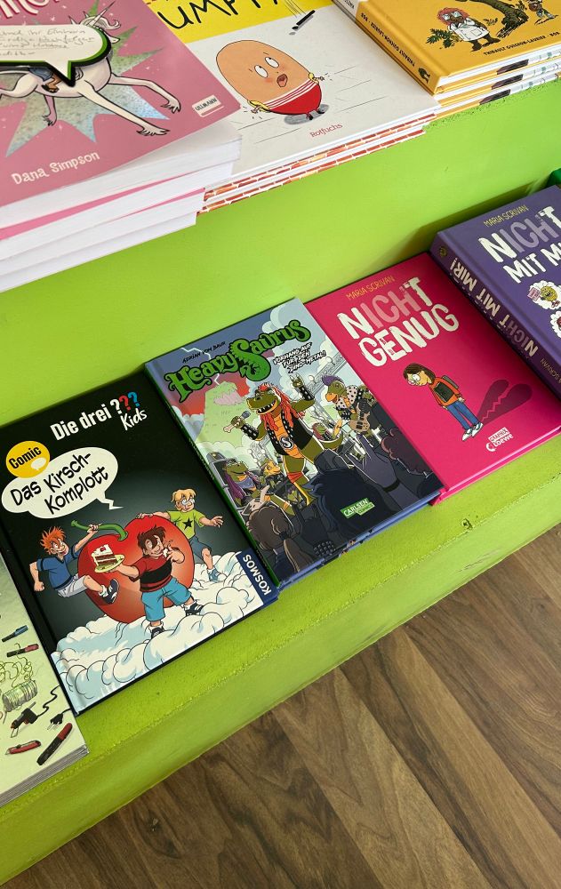 Some kids‘ comics and books at a bookstore display. In the middle, my book: Heavysaurus - der Comic